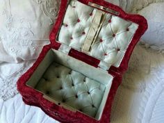 an open red and white box sitting on top of a bed next to a pillow