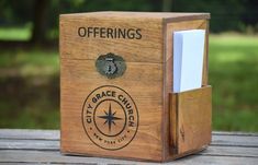 a wooden box with a note pad and business card holder in it on a table