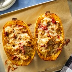 two stuffed squash halves with cheese and meat on a baking sheet next to a cup of coffee