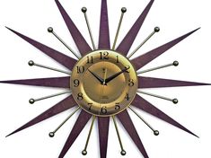 a gold and purple clock with spikes on it's face is shown against a white background