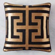 a black and gold pillow on a white wall