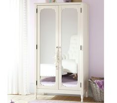 a white armoire with mirrored doors in a room