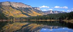 the mountains are reflected in the still water