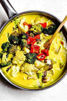 a pan filled with broccoli, cauliflower and red peppers on top of a white table