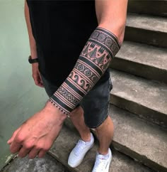 a man with a tattoo on his arm is walking up some steps and pointing at the camera