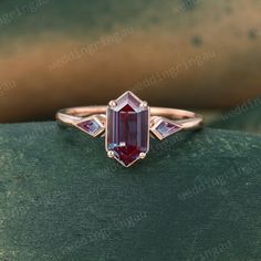 a pink tourmaline ring on top of a green surface