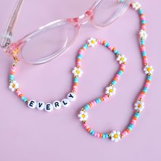 a pair of glasses and beaded name necklace