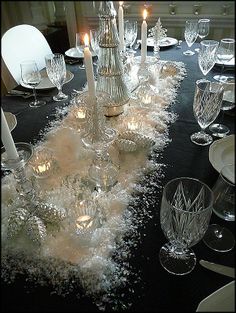 the table is set with candles and glassware for an elegant dinner or party event