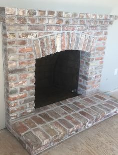 an empty brick fireplace in the corner of a room