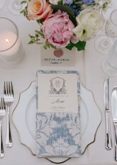 a place setting with silverware and flowers