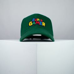 Super gamer / Mario cotton twill baseball cap with a blue, red, yellow, green and black embroidered design. Top your look with Hatty Hats Embroidery embroidered baseball caps. Embroidered with love <3 in the United Kingdom. ♥ Baseball cap with super gamer / Mario embroidered design. ♥ One size fits all unisex hat with adjustable strap at rear. ♥ 100% Cotton twill fabric. ♥ Hat colour available in: Grey / Green / White / Black / Red / Beige / Blue / Navy / Olive Green / Burgundy. ♥ Designed by & exclusive to Hatty Hats Embroidery. ♥ Embroidered in the United Kingdom. View our full assortment of hats here - https://www.etsy.com/uk/shop/HattyHatsEmbroidery 🚚🌎 Free UK shipping on all orders + Free worldwide shipping on orders over $35 / £35 Green Snapback Hat With Letter Print For Streetwear, Green Letter Print Snapback Hat For Streetwear, Green Baseball Cap With Logo Patch For Streetwear, Retro Green Baseball Cap With Curved Bill, Green Baseball Cap With Embroidered Logo, Green Hip Hop Snapback Baseball Cap, Green Baseball Cap With Logo Patch For Sports, Green Cotton Snapback Hat For Streetwear, Green Retro Baseball Cap With Letter Print