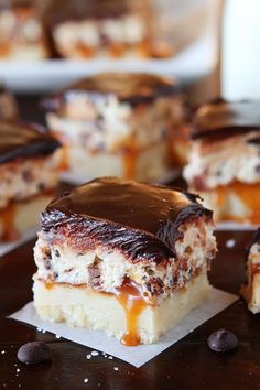 chocolate and caramel dessert bars are sitting on a table with other desserts in the background