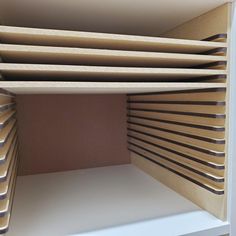 an open book shelf with folded books on it's sides and brown paper covering the shelves