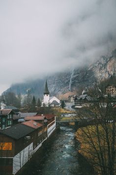 a river running through a small town surrounded by mountains