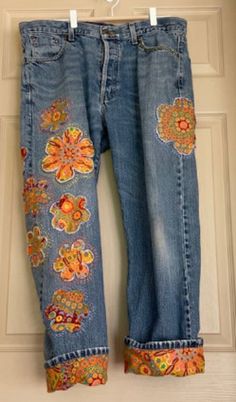 a pair of jeans with embroidered flowers on them