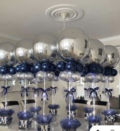 a table topped with lots of silver and blue balloons