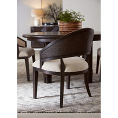 a dining room table with chairs and a potted plant on top of the table