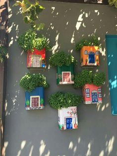 there are many potted plants in the shape of houses on the side of a building