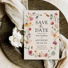 save the date card on a plate with flowers