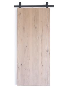 a wooden door hanging on a wall with black metal hardware and wood grained planks