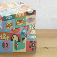 two boxes are stacked on top of each other with different faces painted on the sides