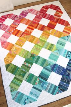 a colorful quilt sitting on top of a wooden floor