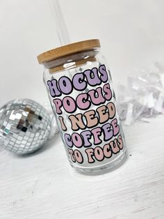 a glass cup with a straw lid and the words rock's pocos i need coffee to focus on it