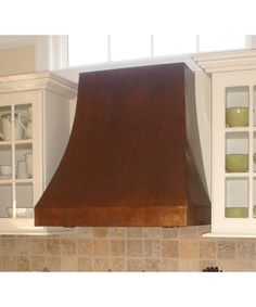 a stove top oven sitting inside of a kitchen next to white cabinets and cupboards