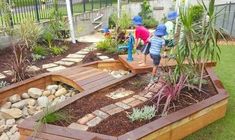 children are playing in the garden with rocks and plants