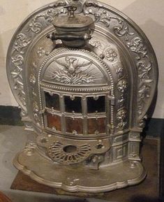 an old fashioned stove sitting on top of a wooden table