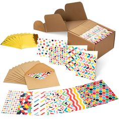 several different types of paper and envelopes on a white surface, including one with colorful designs