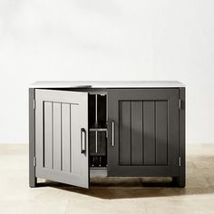 a black and white cabinet sitting on top of a hard wood floor