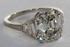 an old cut diamond ring with three baguets on the sides and four prongs