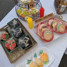 several trays of food are sitting on a table next to other containers and baskets