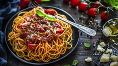 a plate of spaghetti with tomato sauce, parmesan cheese and basil on the side