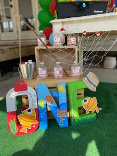 a table topped with lots of toys on top of a green grass covered field next to a soccer goal