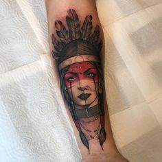 a woman's face with feathers on her head is shown in this tattoo design