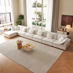 a living room with a large white couch and wooden coffee table in front of a window