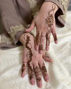 two hands with henna tattoos on them