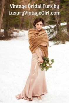 a woman standing in the snow wearing a fur stole