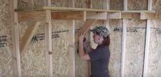 a woman is working on framing the walls