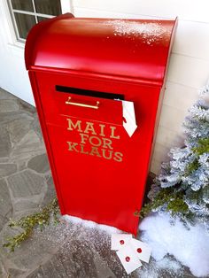 a red mail box sitting next to a christmas tree