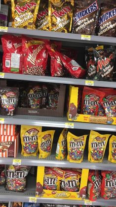 many bags of candy are on shelves in a store