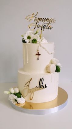 a wedding cake with white flowers and gold lettering