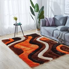 a living room area with a couch, chair and rug in orange and brown tones