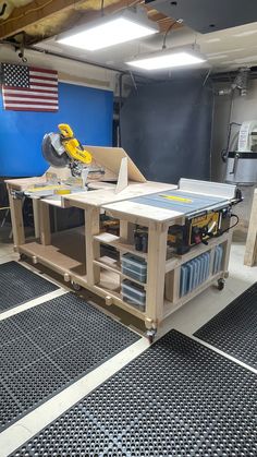 a workbench in a garage with tools on it and an american flag hanging from the ceiling