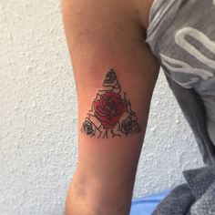 a woman's arm with a rose tattoo on the left side of her arm