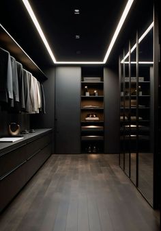 an empty walk in closet with clothes hanging on the walls and lights shining down from the ceiling