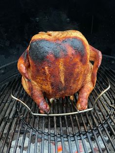 a large chicken is cooking on the grill