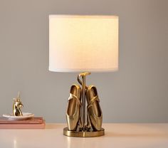 a lamp that is sitting on top of a table next to a book and some books